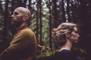 Couple with back to each other in forest